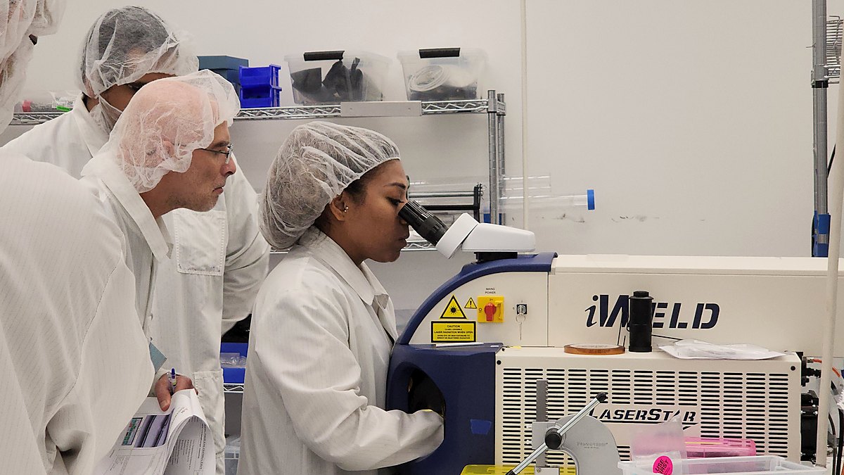 AuST technicians at a laser welding station in the cleanroom